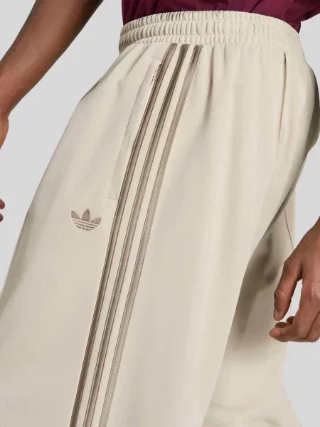 Spodnie dresowe o kroju loose fit z mieszanka bawełny z kantami Adidas Originals