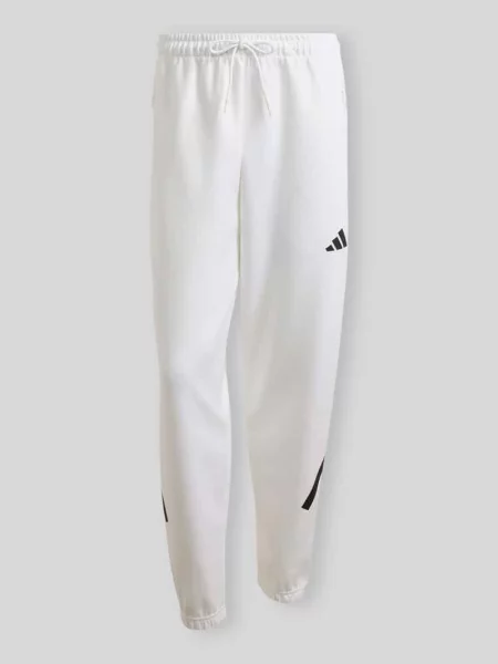 Spodnie dresowe o kroju regular fit z domieszką bawełny Adidas Sportswear białe