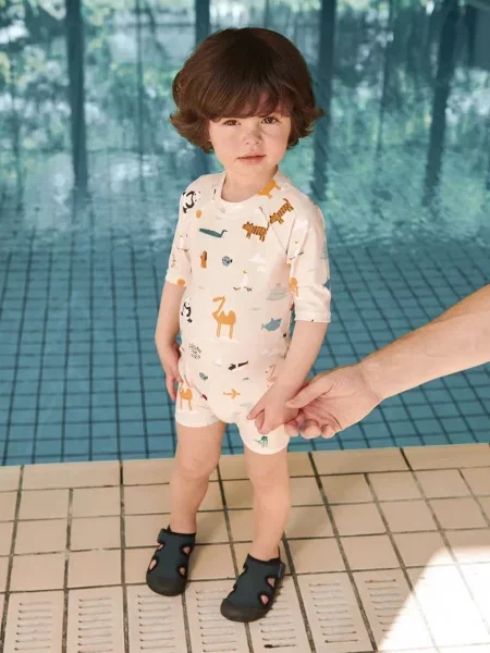 Liewood plážový overal dětský Thor Baby Swim Jumpsuit béžový