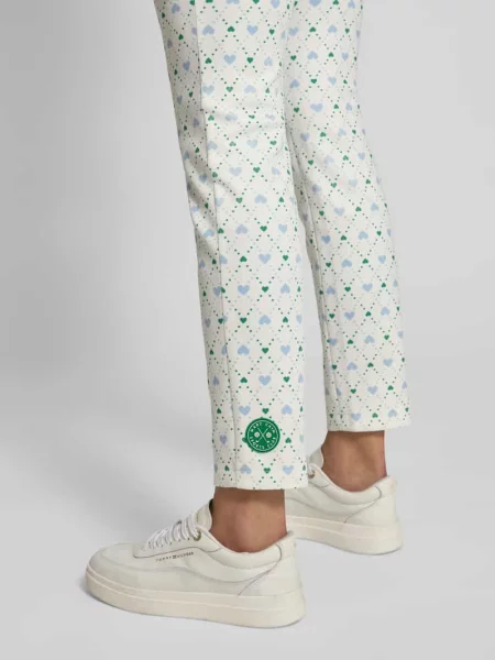 Spodnie materiałowe o kroju slim fit z nadrukiem z logo na całej powierzchni Marc Cain białe