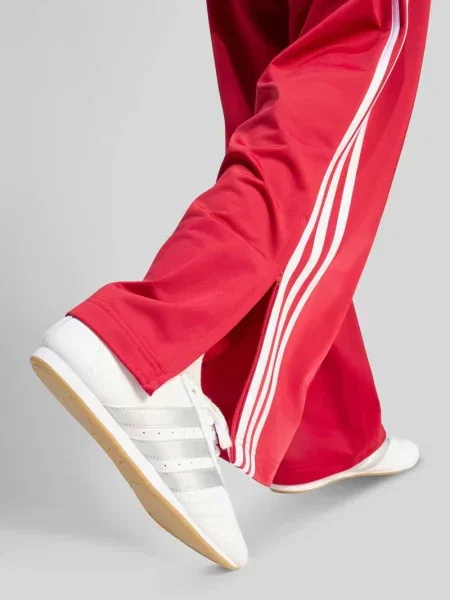 Spodnie dresowe o kroju loose fit z paskami w kontrastowym kolorze Adidas Originals czerwone