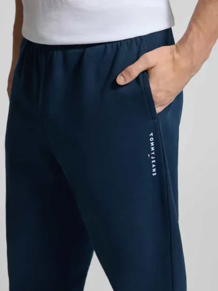 Spodnie dresowe o kroju regular fit z mieszanki bawełny Tommy Jeans granatowe