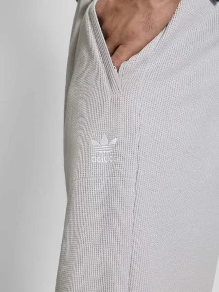 Spodnie dresowe o kroju straight fit z fakturowanym wzorem Model „Essentials” Adidas Originals
