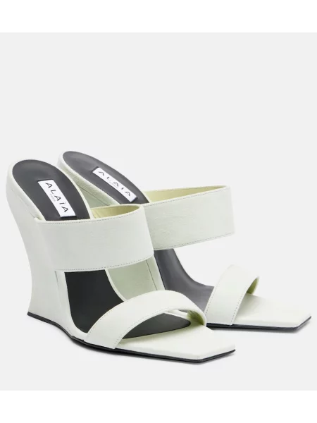 Papuci tip mules Alaïa din piele de căprioară cu pană alb