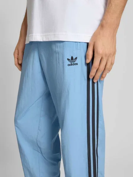 Spodnie dresowe o kroju regular fit z wyhaftowanym logo model ‘FIREBIRD’ Adidas Originals niebieski